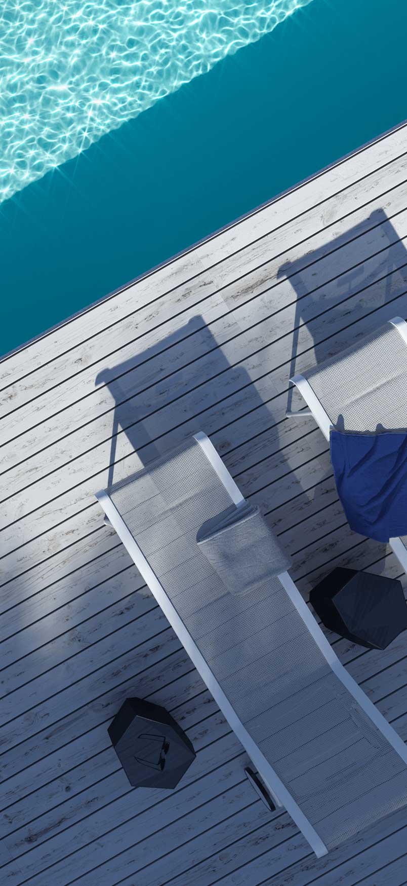 Two lounge chairs next to an inground pool in a residential backyard.