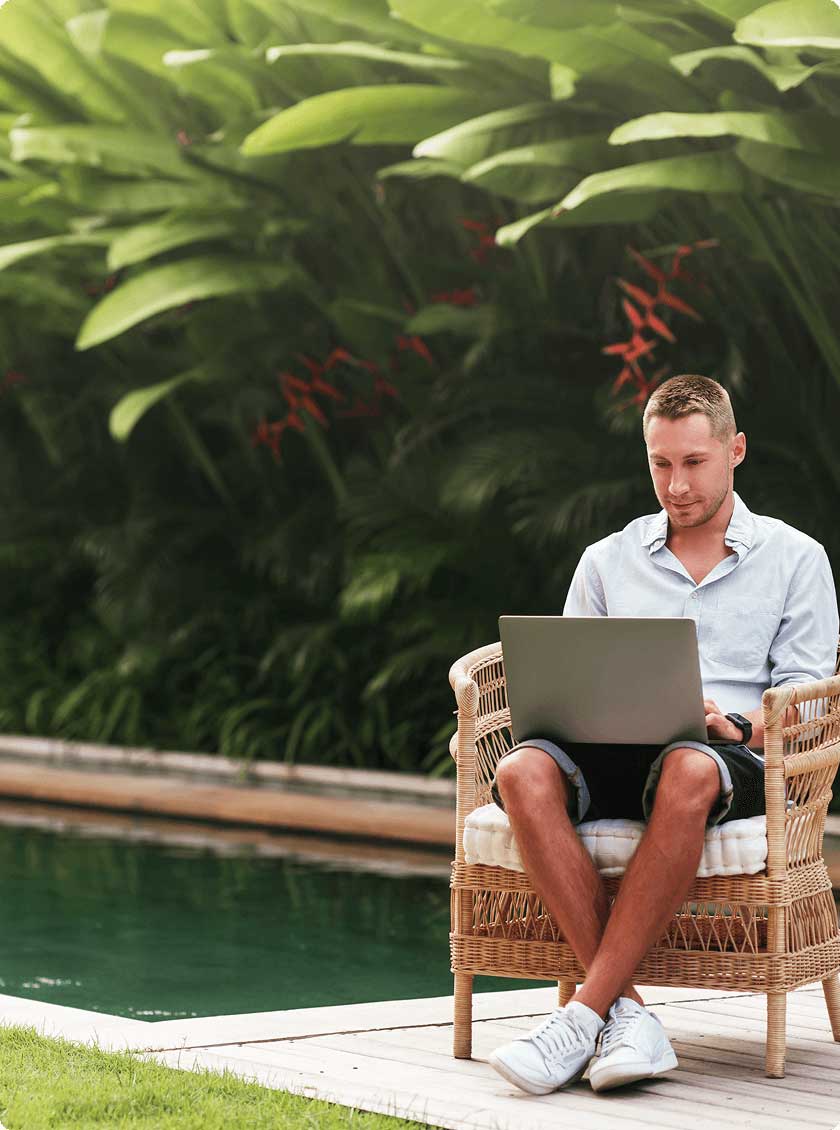 Man sitting in chair next to a backyard pool.