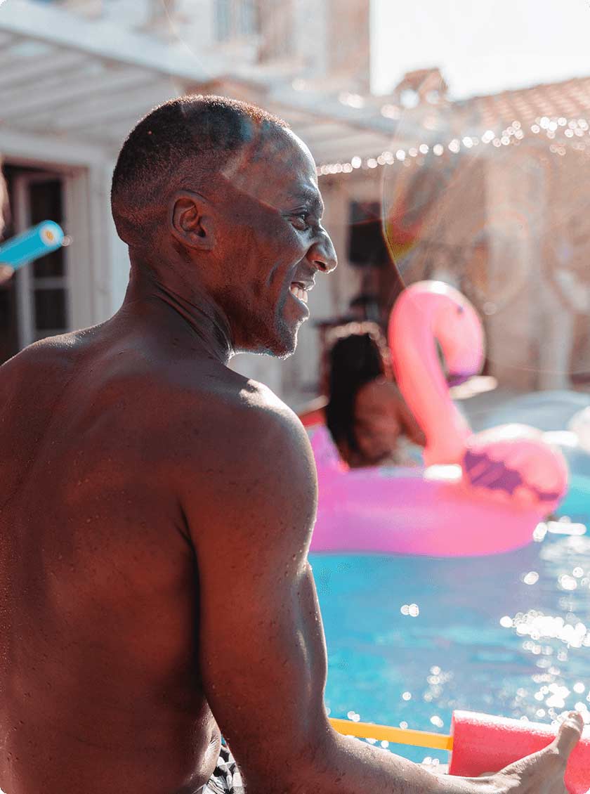 Man smiling next to inground pool.