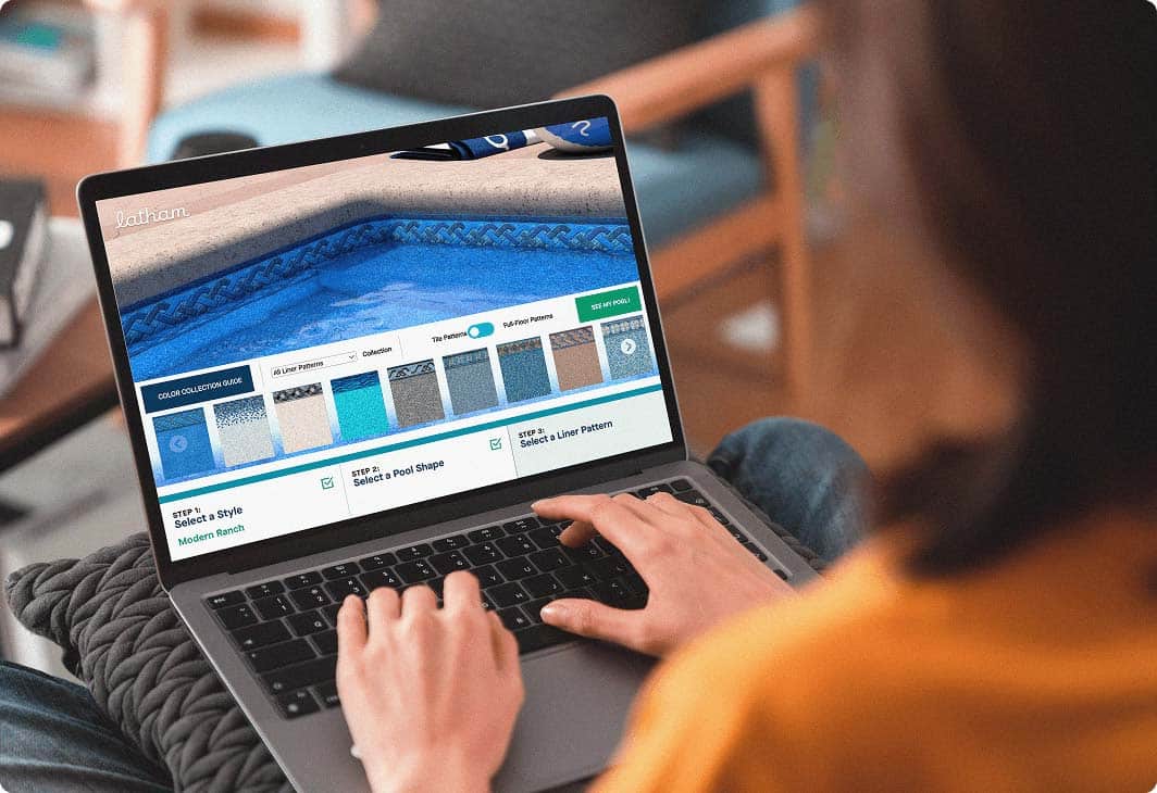 Person on laptop interacting with Latham's software for designing pool shapes and features.