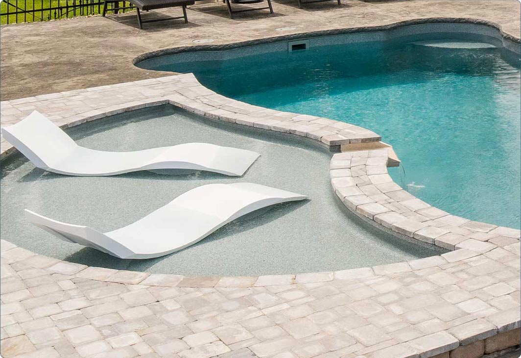 Shallow tanning ledge with partially submerged lounge chairs