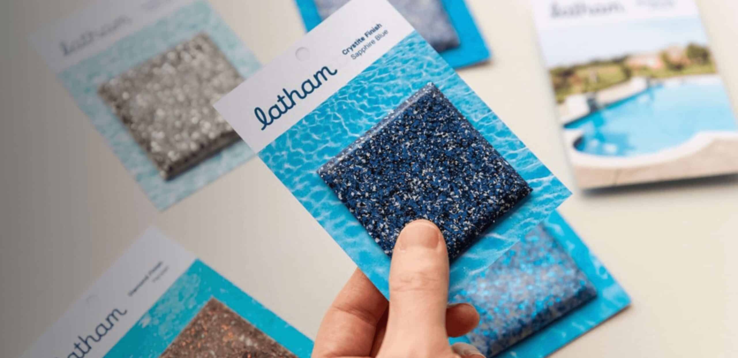 Hand holding fiberglass color samples with various textured finishes displayed.