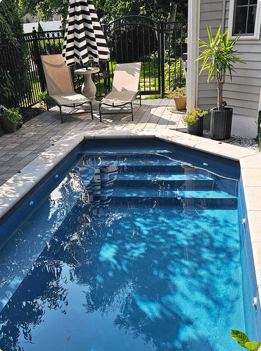 Narrow backyard pool framed by radiant wall panels and surrounded by greenery.