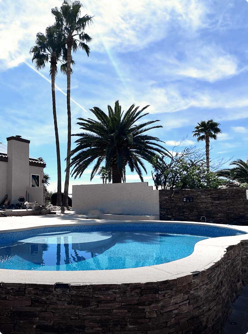 Vinyl spa and pool with stone coping and light-colored decking.