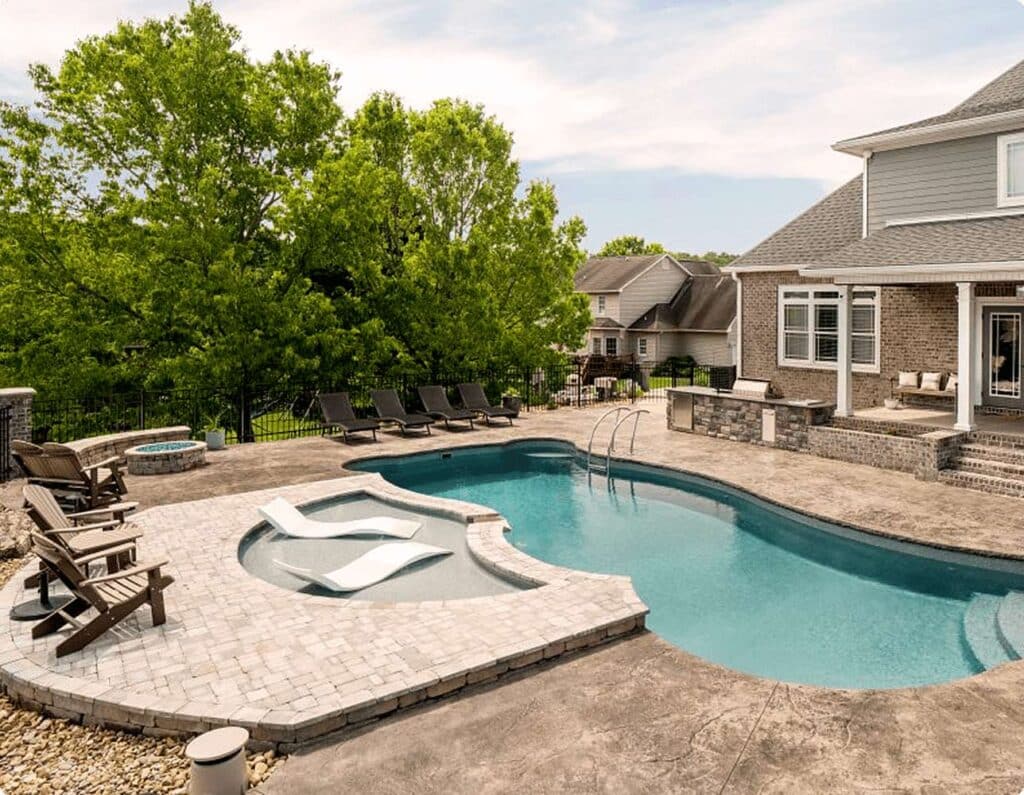 spacious backyard with inground pool, tanning ledge and raised patio