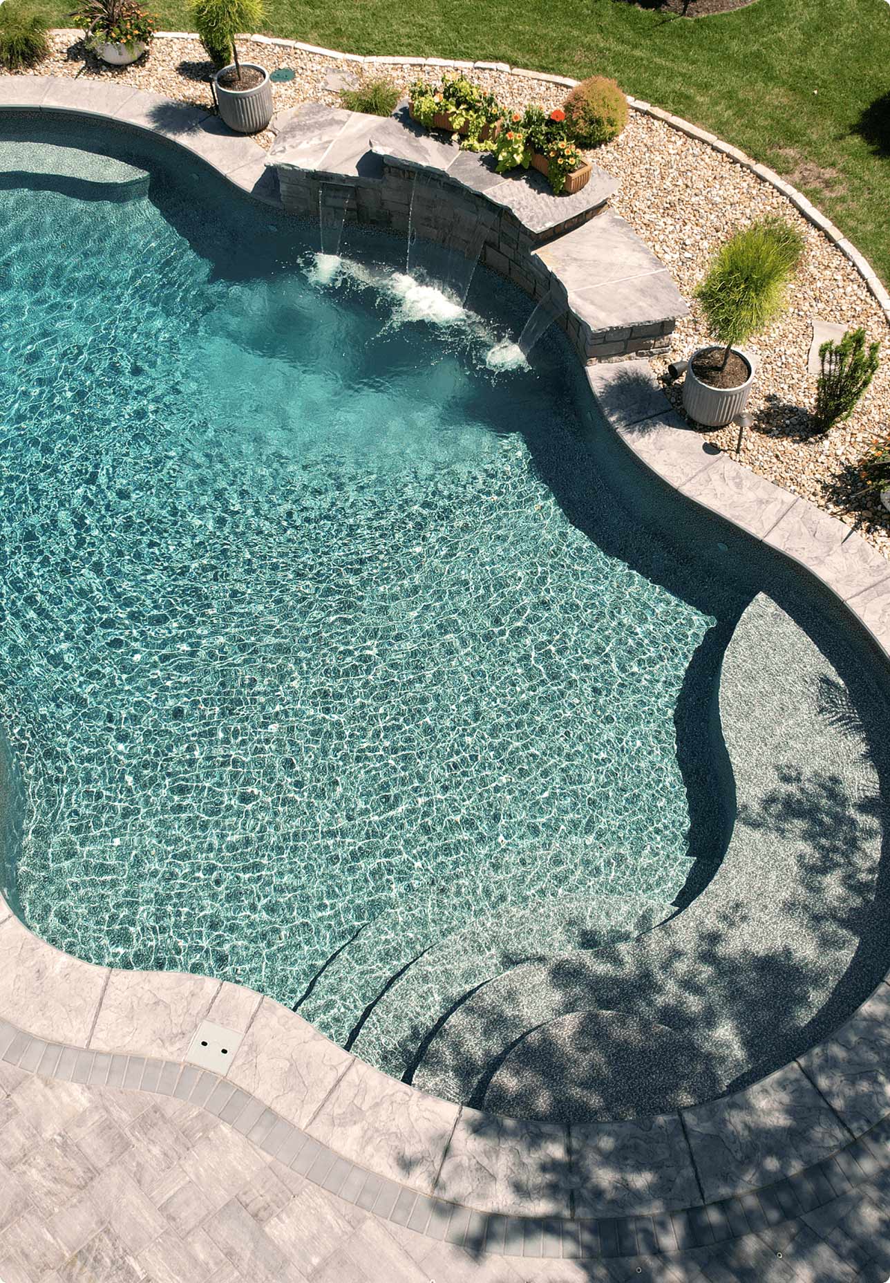 overhead view of backyard with fiberglass inground pool with water features