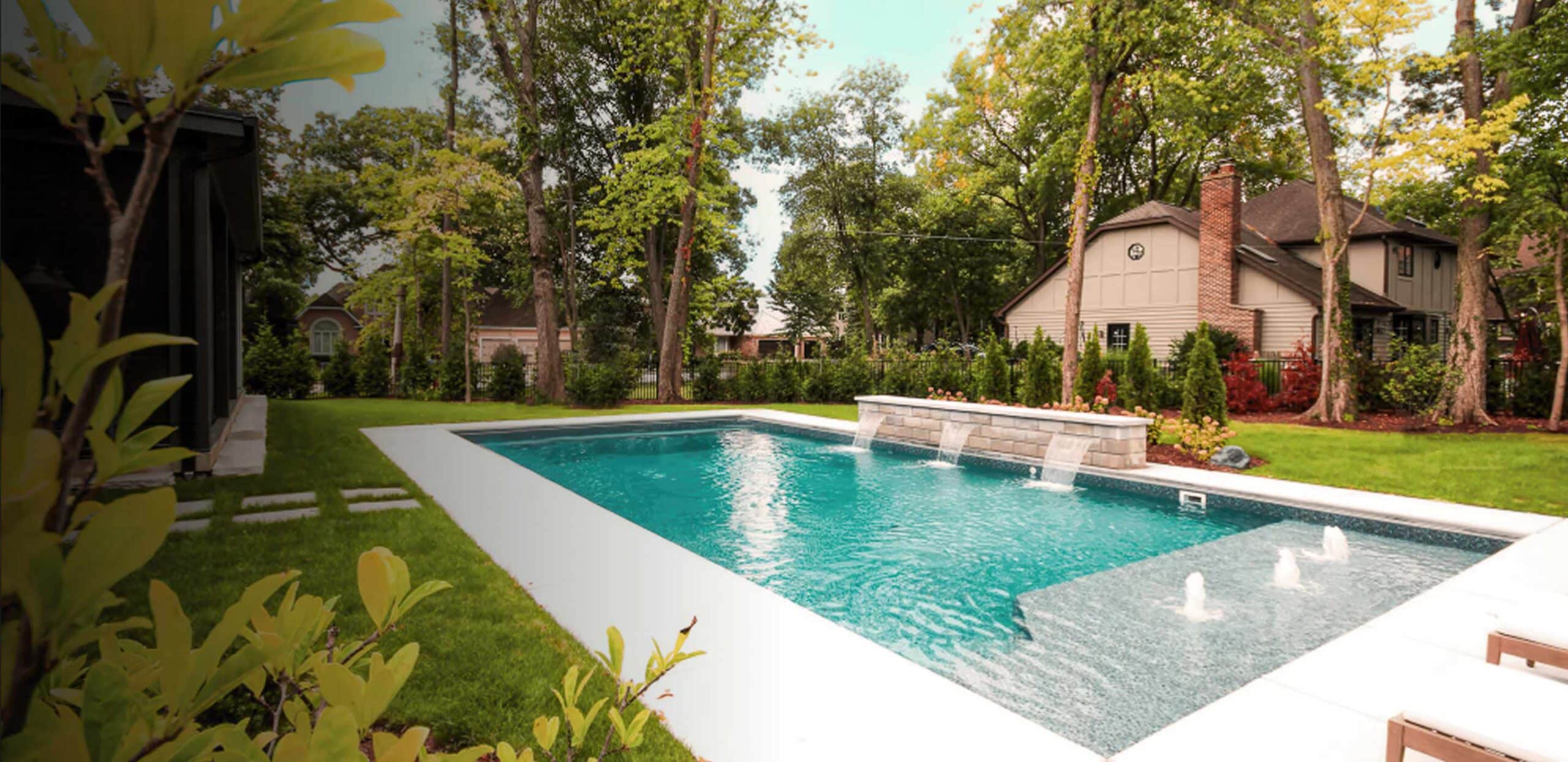 beautiful backyard with inground pool that has water features and spacious tanning ledge