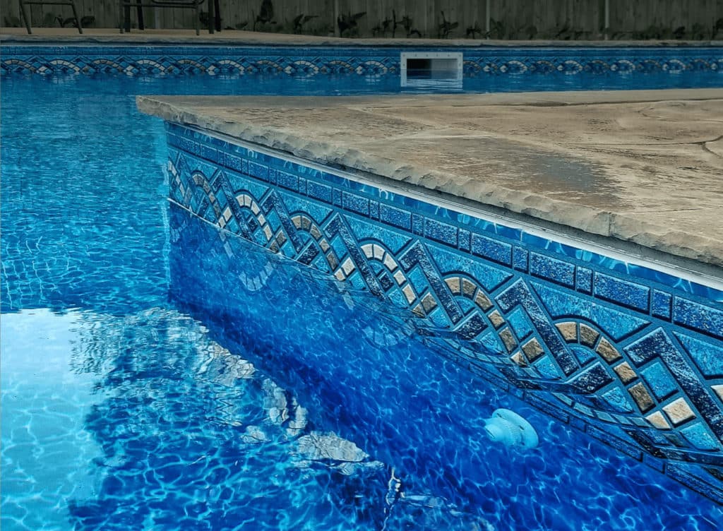 Blue vinyl pool liner with Panama (solid medium blue) color and Royal Prism (textured mosaic tile pattern) on the floor