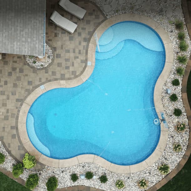 Bird's-eye view of a sparkling inground pool with a vintage blue mosaic tile pattern.