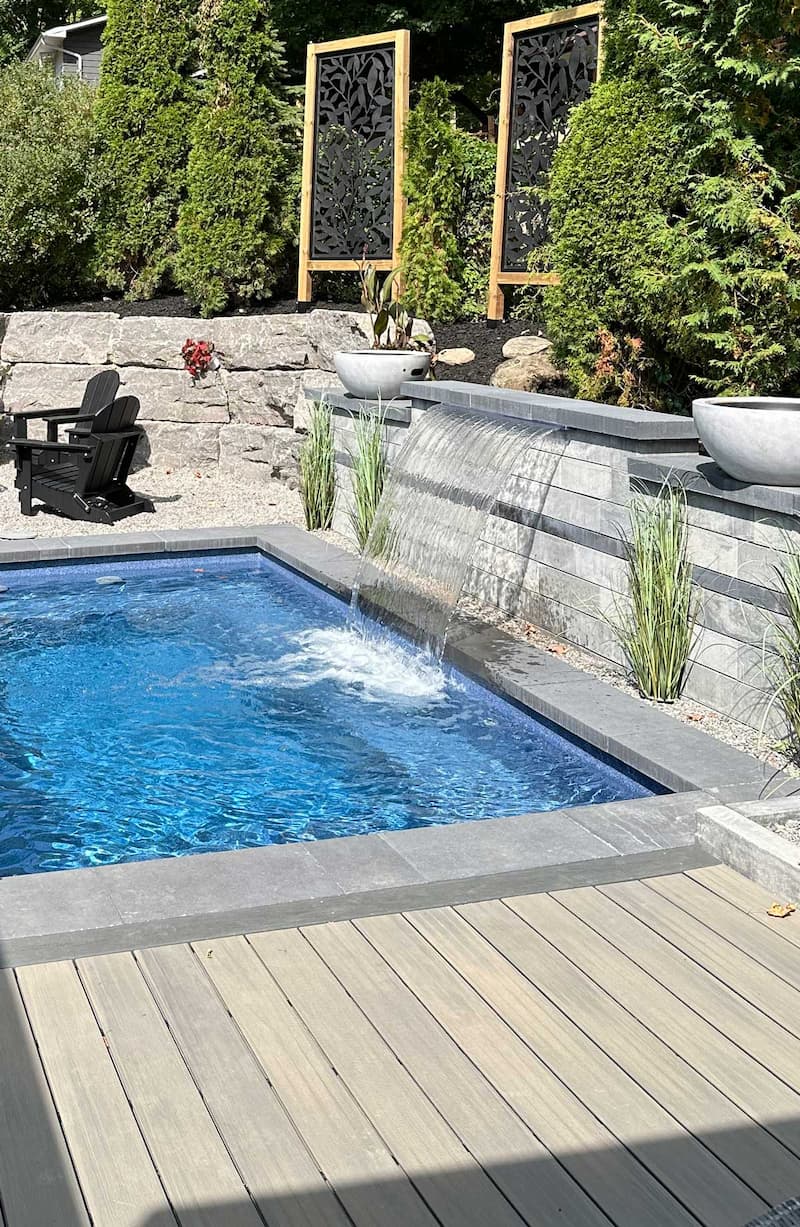 Inground pool with waterfall feature spilling into main pool.
